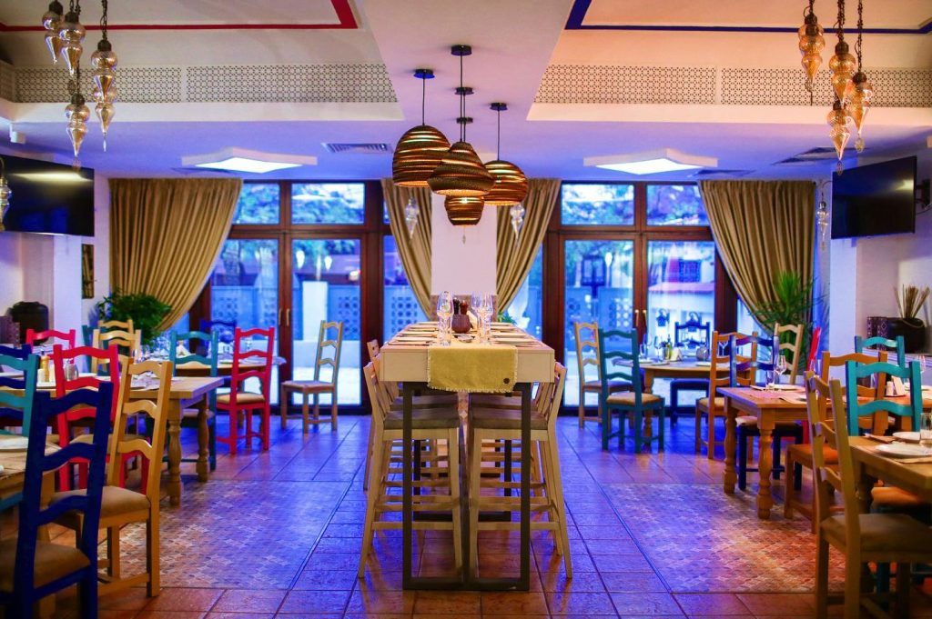 Spațiu de dining cu arhitectură orientală: iluminat cald, arcade ornate și detalii sculptate care transformă experiența culinară într-o călătorie culturală autentică.