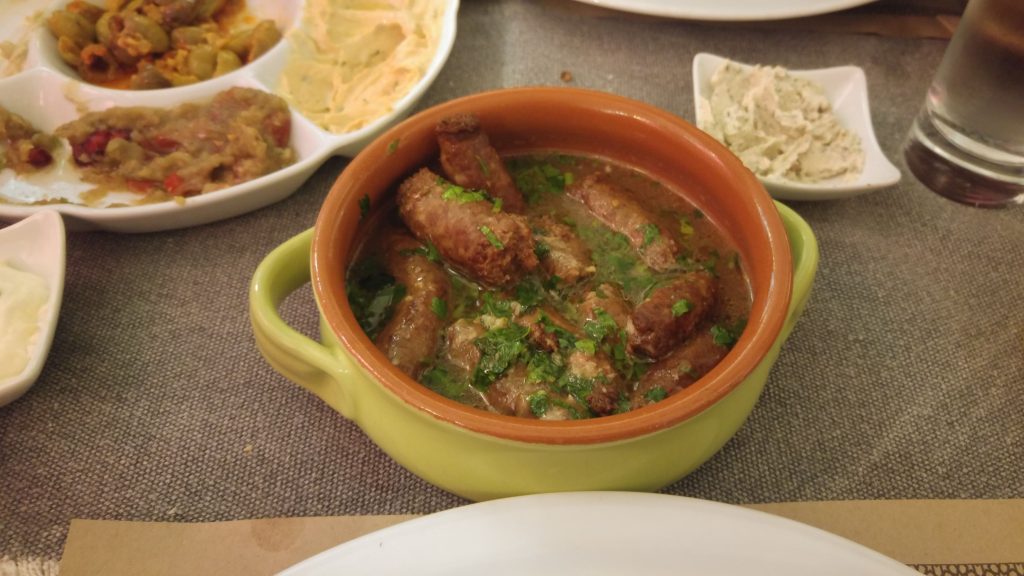 Preparat culinar cu iz oriental: creație strălucitoare pe farfurie întunecată, decorată cu ingrediente proaspete și condimente exotice, reprezentând esența bucătăriei libaneze autentice.