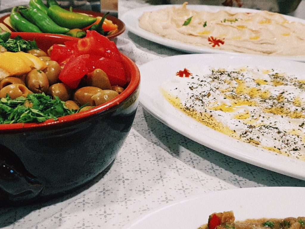 Preparat culinar cu iz oriental: creație strălucitoare pe farfurie întunecată, decorată cu ingrediente proaspete și condimente exotice, reprezentând bogăția și autenticitatea bucătăriei libaneze.